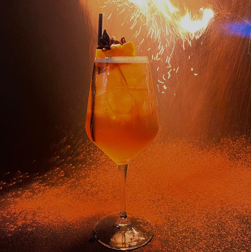 Cocktail with firework display behind the drink at Manor House Lindley